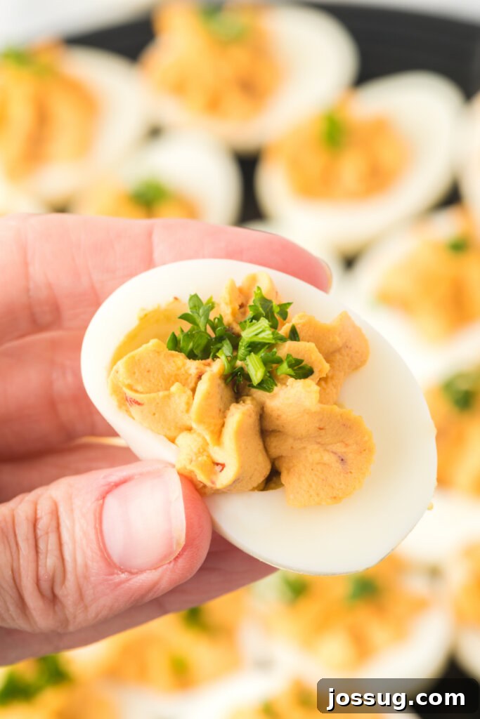 Smoky Chipotle Deviled Eggs 2 hand holding chipotle deviled egg