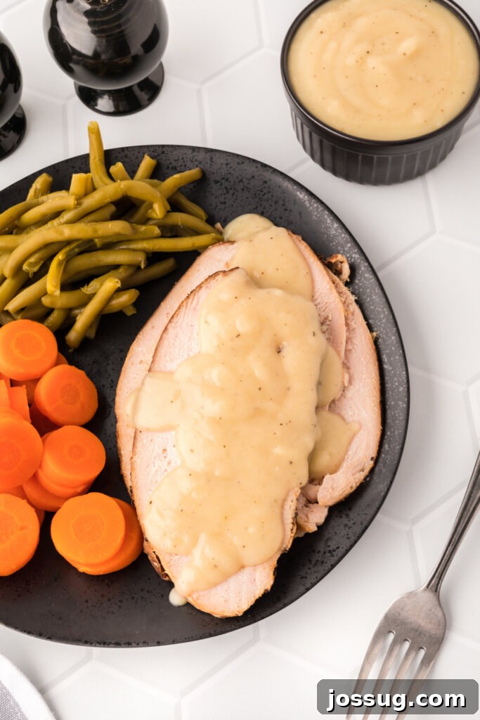 Mastering the Art of Gravy 4 Slices of perfectly roasted turkey breast generously covered in a rich, homemade gravy, highlighting its delicious texture.