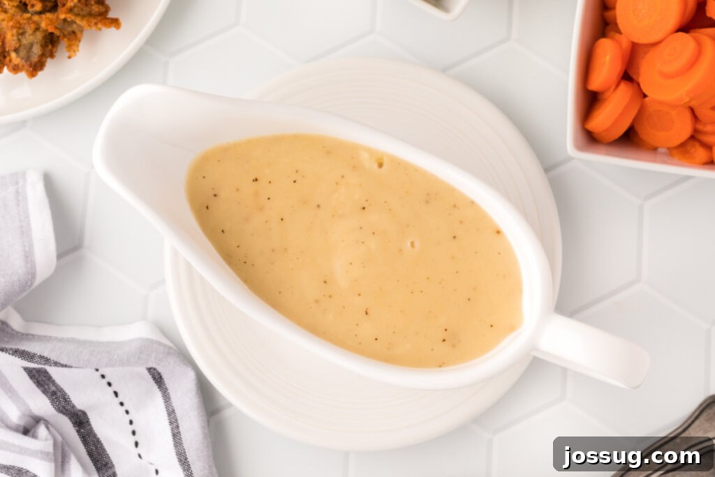Mastering the Art of Gravy 6 A pristine white gravy boat filled to the brim with smooth, golden-brown homemade gravy, ready for serving.