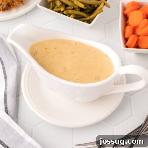 Closeup of perfectly smooth gravy in a white gravy boat, ready for serving.