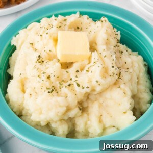 mashed potatoes topped with butter pat in bowl