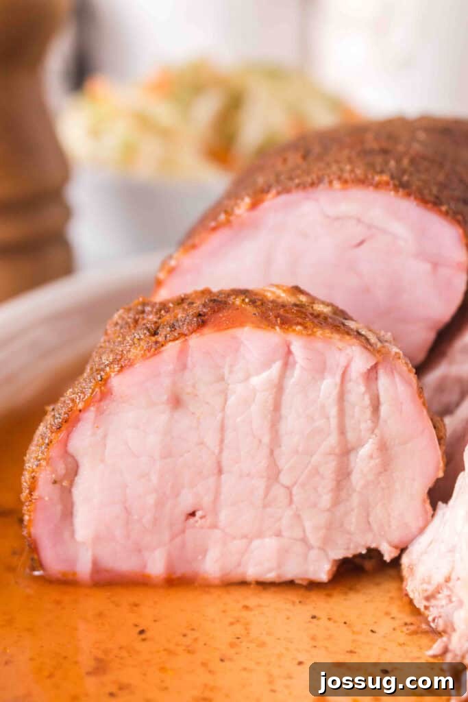 Close-up of sliced smoked pork tenderloin showing juicy interior and spice rub