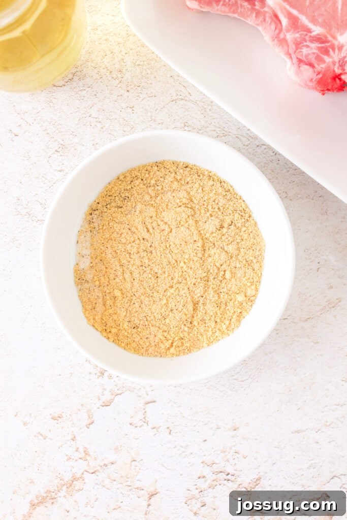 Effortlessly Delicious Smoked Pork Chops 6 A perfectly blended dry rub of mixed spices rests in a white ceramic bowl, showcasing its fine texture and rich color, ready to season the pork chops.