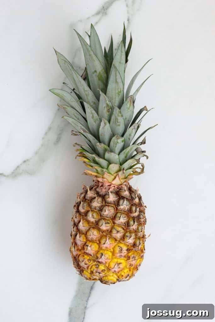 Whole fresh pineapple on a white marble surface