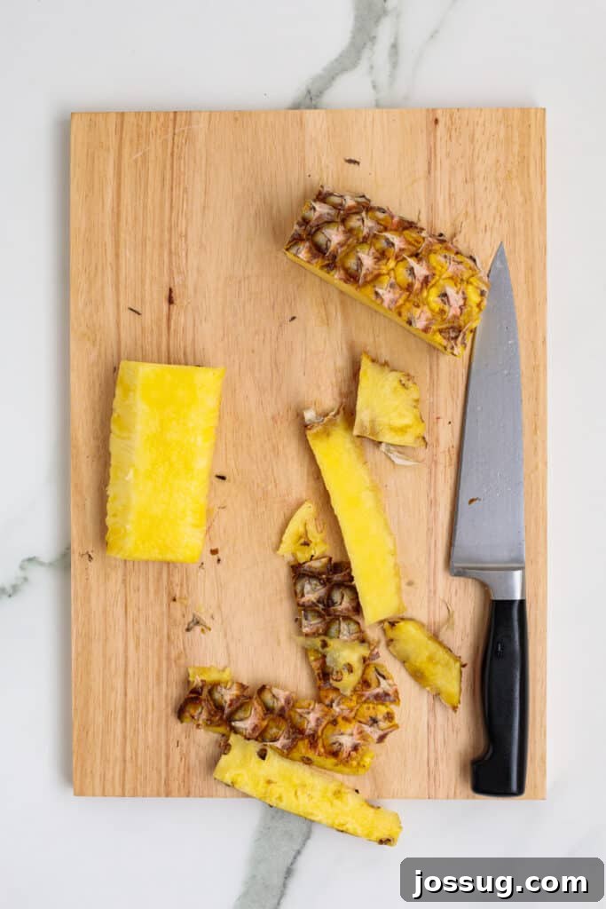 Pineapple pieces with peel and core removed, ready for slicing