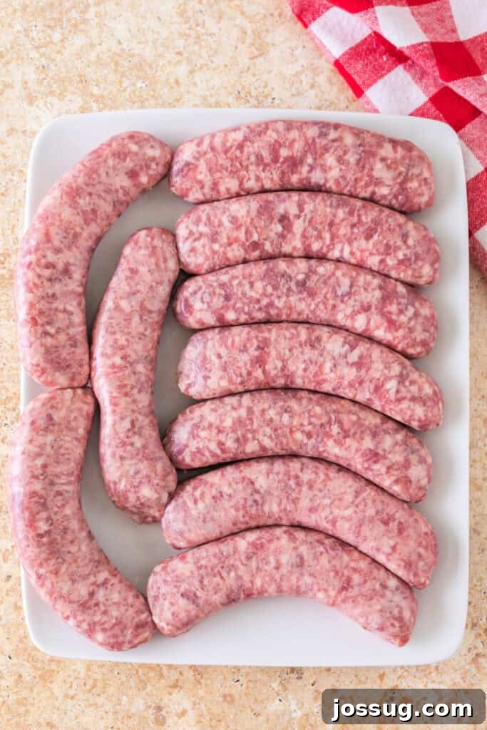 Raw bratwurst sausages neatly arranged on a pristine white plate, awaiting their transformation in the smoker.