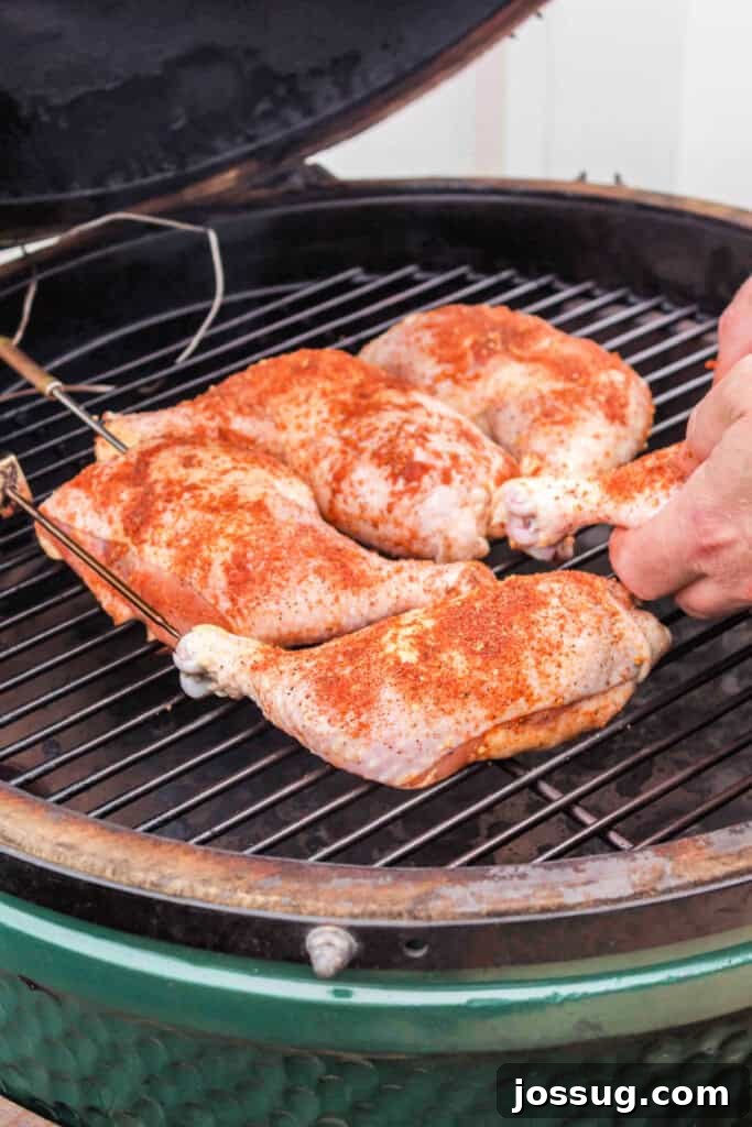 Succulent Smoked Chicken Legs 5 Raw seasoned chicken quarters being carefully arranged on the smoker grill grate, skin-side up.
