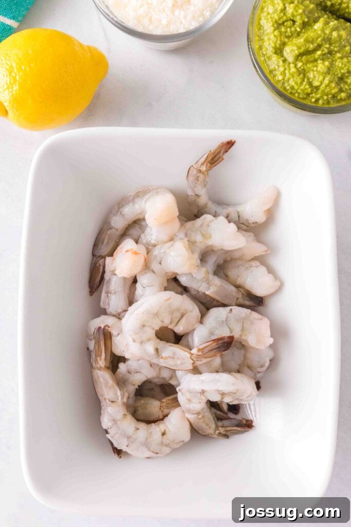 Zesty Grilled Pesto Shrimp 3 Raw jumbo shrimp in a white bowl, ready to be marinated with pesto.