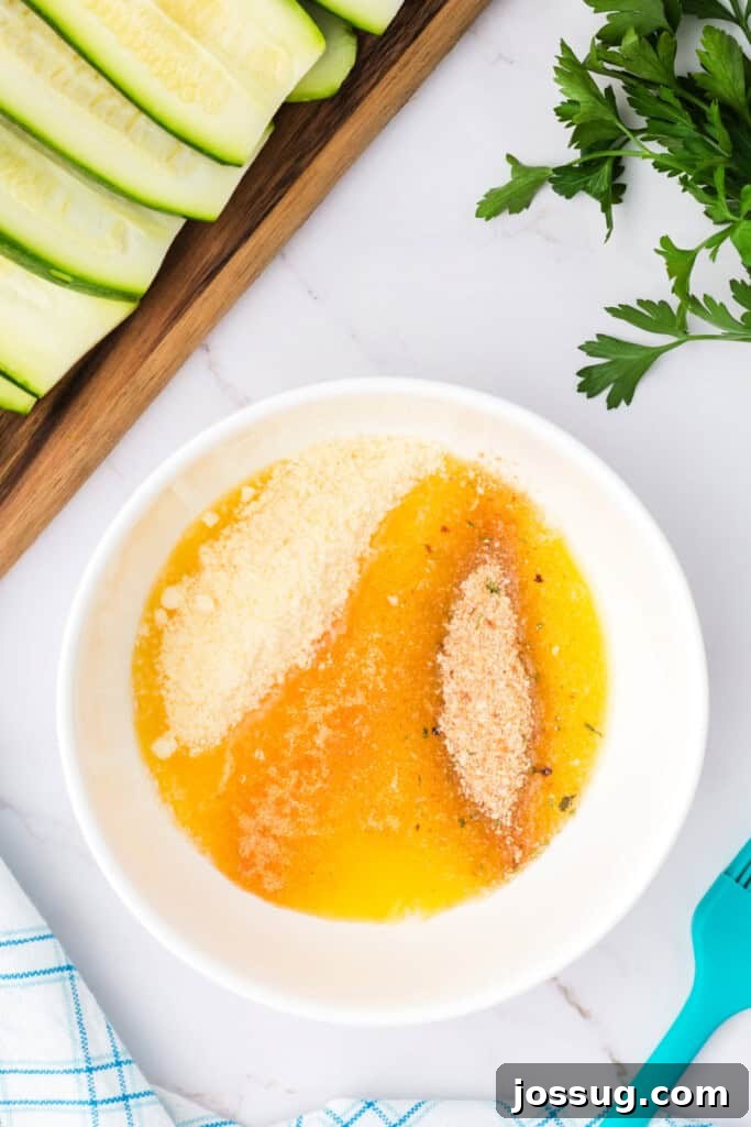 A bowl with melted butter, grated parmesan, and Italian breadcrumbs, ready for mixing.
