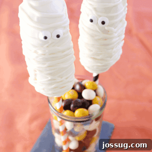 Halloween Twinkie Mummies 3 Mummy Twinkie Pops in a glass jar with jelly beans.