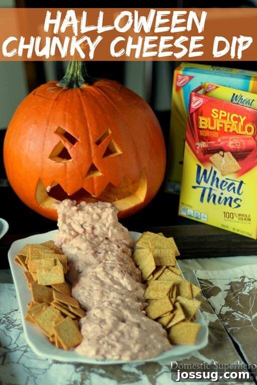 A festive Halloween chunky cheese dip in a white bowl, surrounded by crackers ready for dipping.