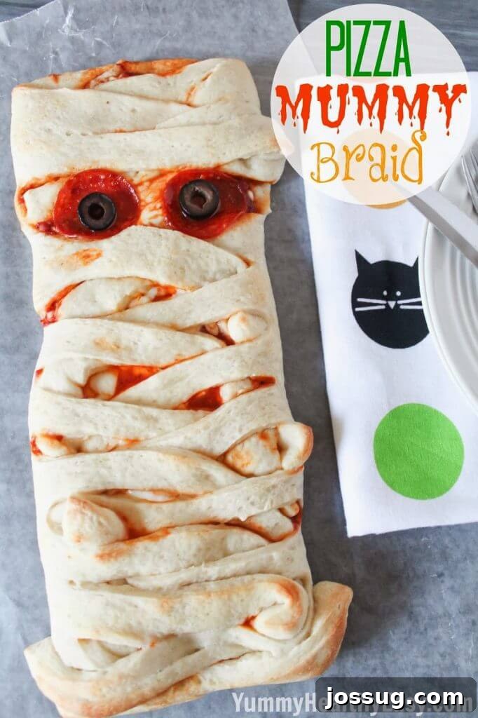 A golden-brown Pizza Mummy Braid, shaped like a wrapped mummy and filled with pizza ingredients.