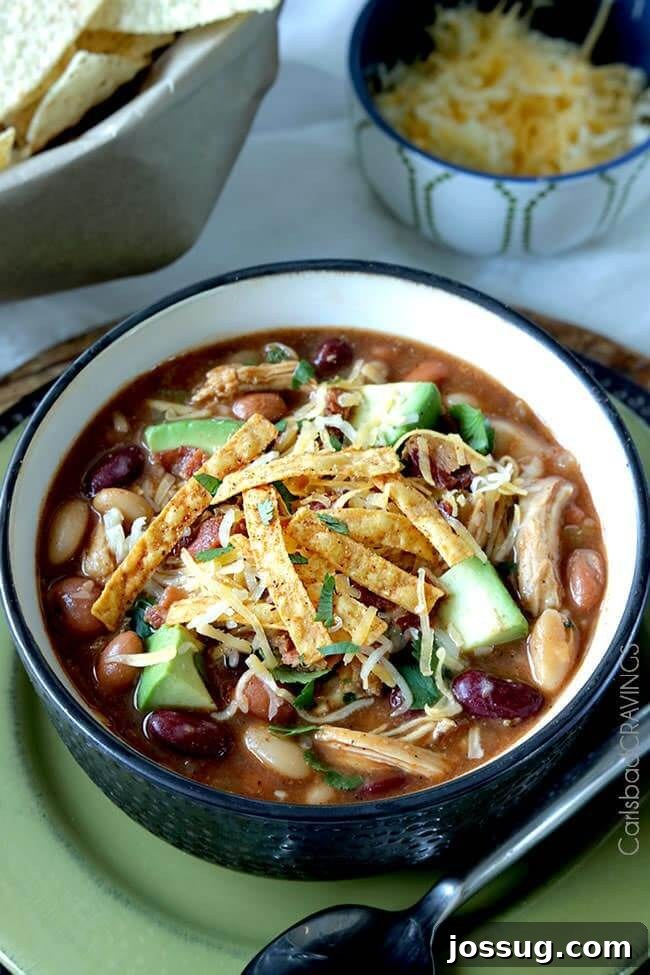 A rich and hearty bowl of Sweet and Smokey Barbecue Chicken Chili, garnished and ready to serve.