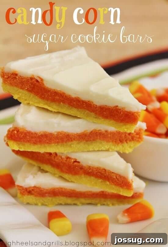 Stacked Candy Corn Sugar Cookie Bars on a white plate, showcasing their distinctive yellow, orange, and white layers.