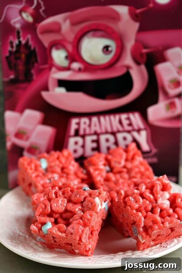 Bright pink Frankenberry Krispies treats, shaped and decorated, presented on a white plate.