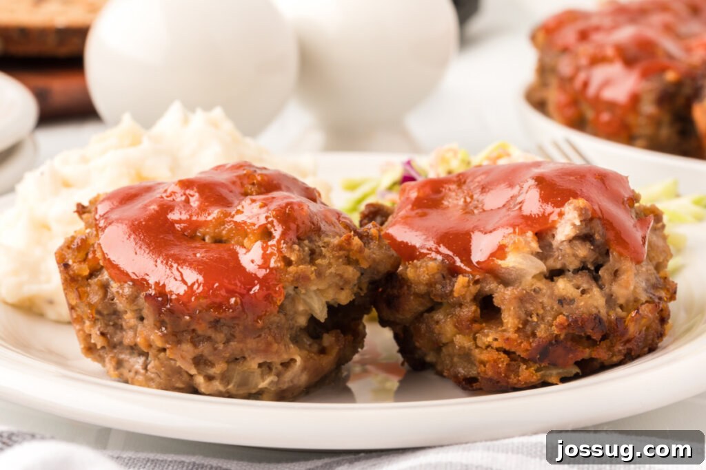 Meatloaf Minis 5 Two beautifully baked meatloaf muffins presented on a simple white plate, ready for a satisfying meal.