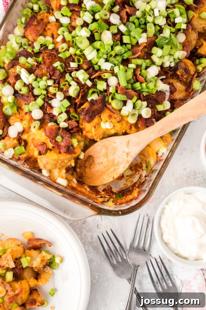 Fully Loaded Chicken Potato Bake 2 Loaded Potato and Chicken Casserole in a baking dish with a scoop taken out, revealing the creamy, cheesy interior