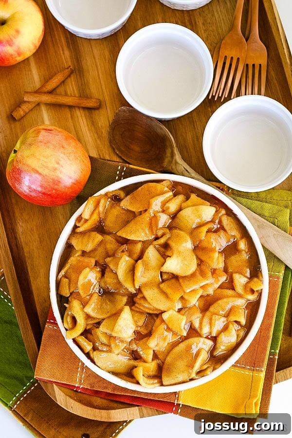 A beautifully set fall table featuring a bowl of warm fried apples, surrounded by autumn decor.