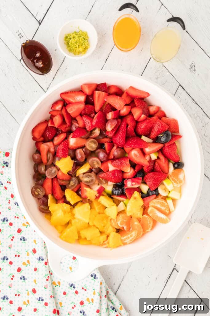 Vibrant Fruit Mosaic with Zesty Honey Glaze 5 All prepped fruits placed in a large white mixing bowl.