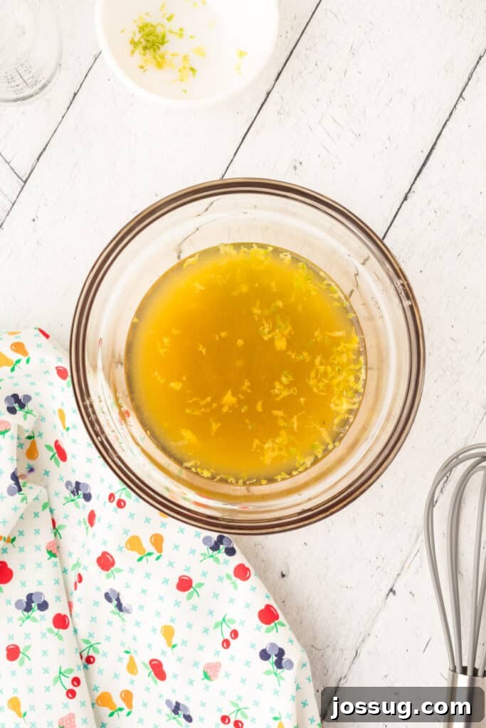 Vibrant Fruit Mosaic with Zesty Honey Glaze 6 Lemon and orange juice being whisked together in a bowl.