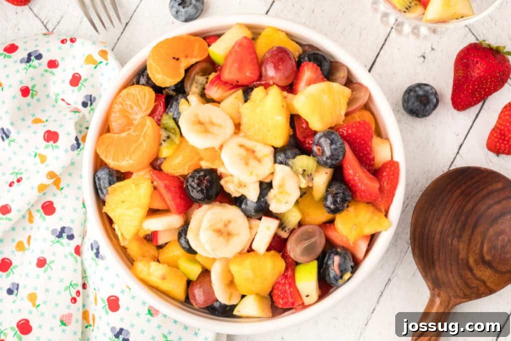Vibrant Fruit Mosaic with Zesty Honey Glaze 10 Easy fruit salad with honey citrus dressing in a white bowl, ready to serve.