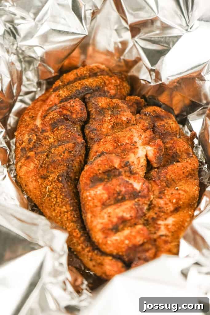 Smoked turkey breast resting inside a foil wrap after cooking