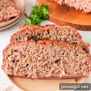 Three thick slices of smoked meatloaf on a plate with fresh parsley garnish