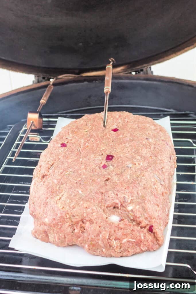Pit Smoked Meatloaf 8 The raw meatloaf carefully positioned inside a preheated smoker, with temperature probes inserted to monitor internal doneness.
