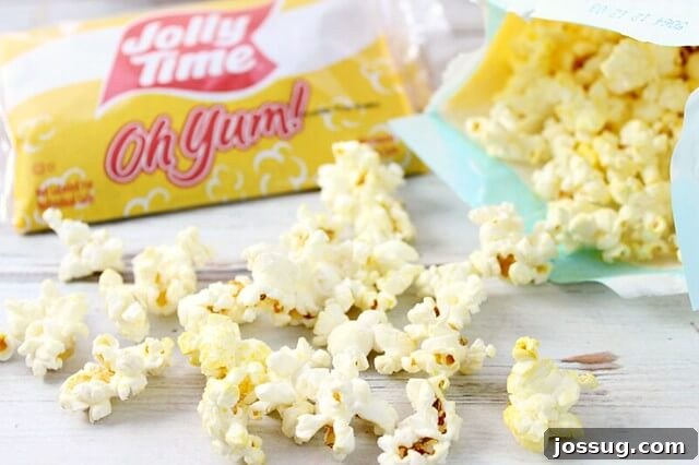JOLLY TIME Oh Yum popcorn kernels spread out on a wooden cutting board, symbolizing the start of a delicious snack.