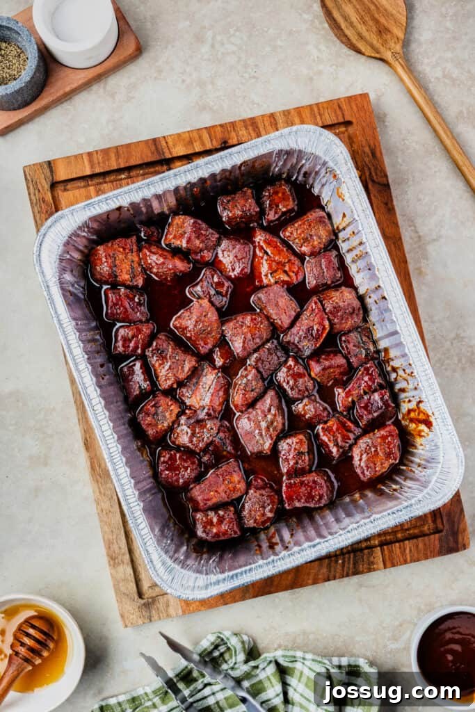 Burnt Ends on a Budget 9 Fully cooked burnt ends in a foil pan, coated in rich, sticky BBQ glaze, glistening and tender.