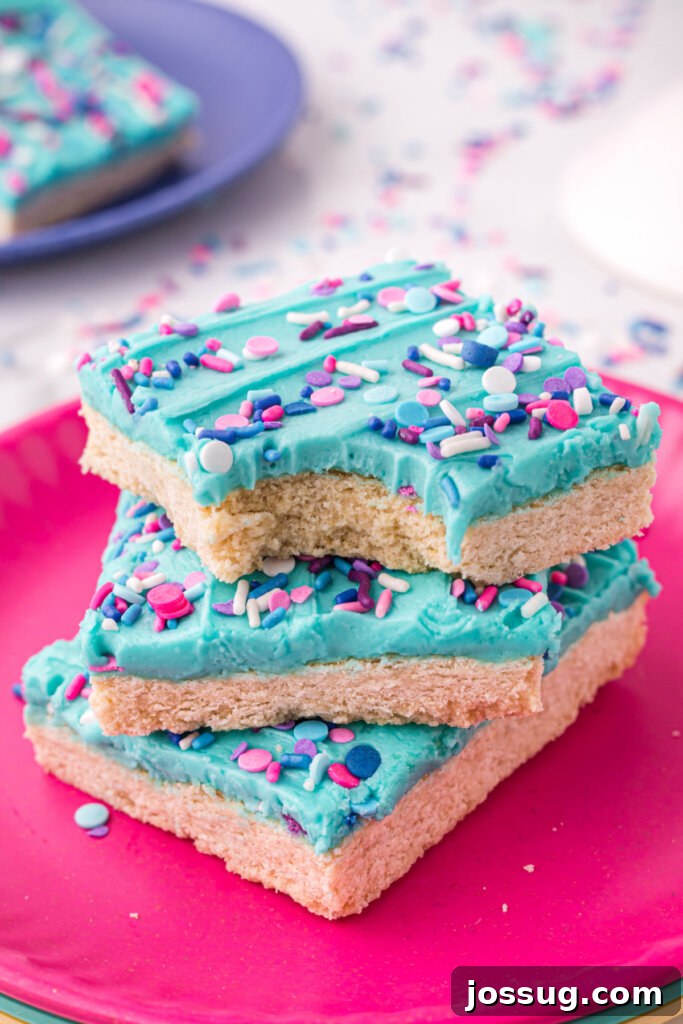 Delicious sugar cookie bars stacked, with a bite taken out of the top one.