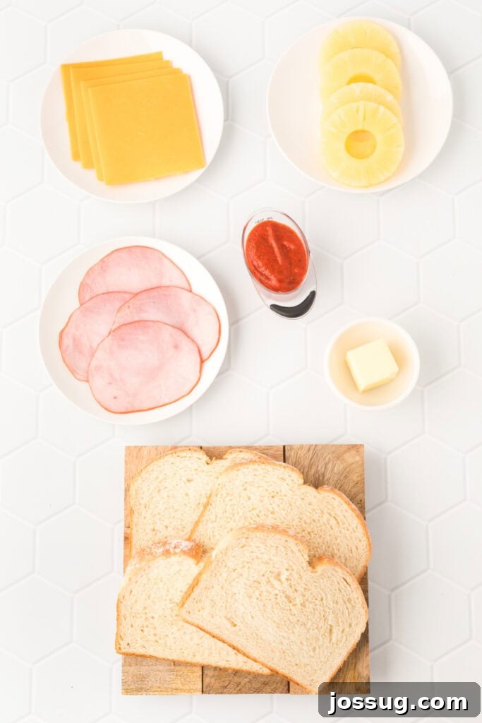 Aloha Grilled Cheese 3 Ingredients laid out for a Hawaiian Pizza Grilled Cheese Sandwich, including bread, butter, pizza sauce, Canadian bacon, pineapple rings, and cheddar cheese slices