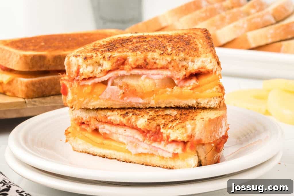 Aloha Grilled Cheese 6 A sliced Hawaiian Pizza Grilled Cheese Sandwich on a plate, ready to be served