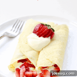 Strawberry & Lemon Cream Crepes on a white plate with a fork.