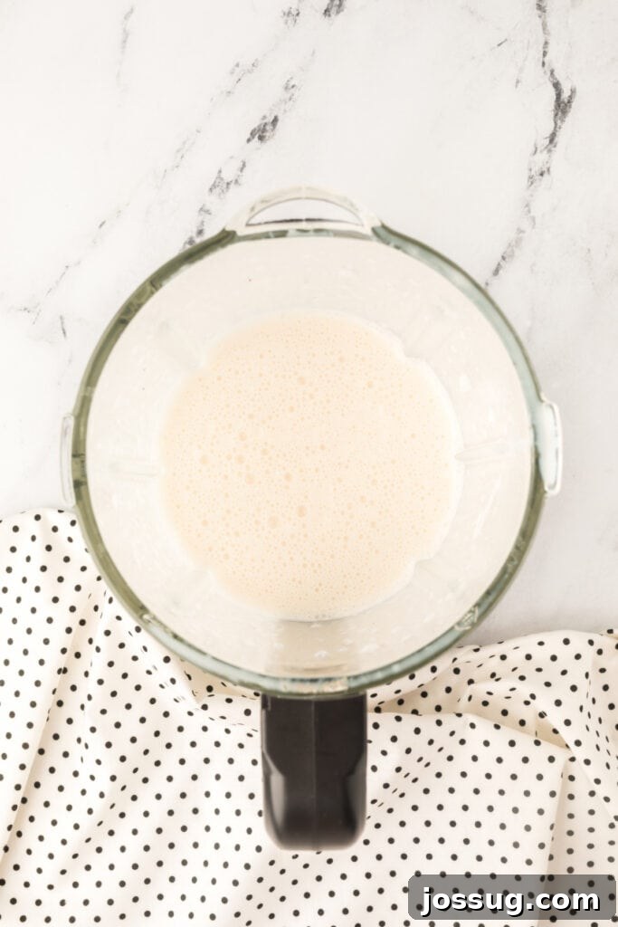 The perfectly blended Dirty Banana Cocktail mixture inside a blender, showcasing its smooth, frothy, and creamy texture, ready to be poured.