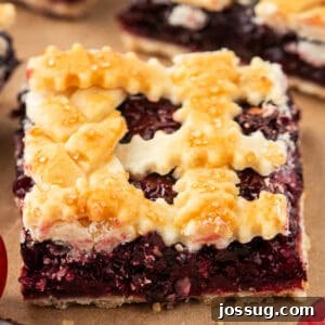 Close-up of a single cherry pie bar square with a crimped lattice crust and golden sugar topping