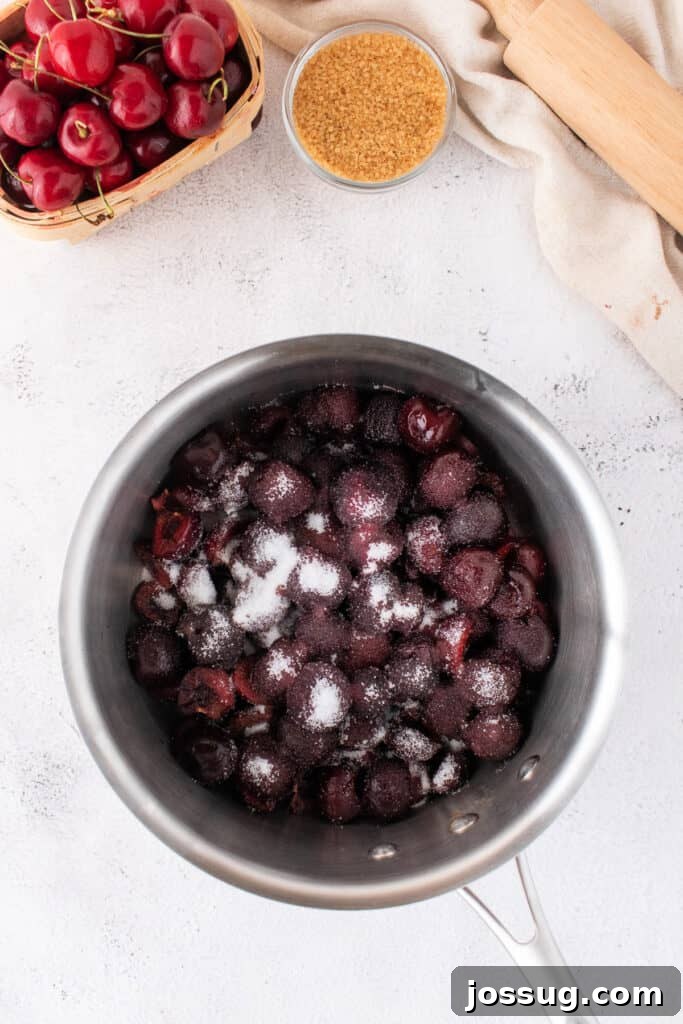 Sweet Cherry Pie Bars 4 Frozen cherries sprinkled with granulated sugar inside a stainless steel saucepan