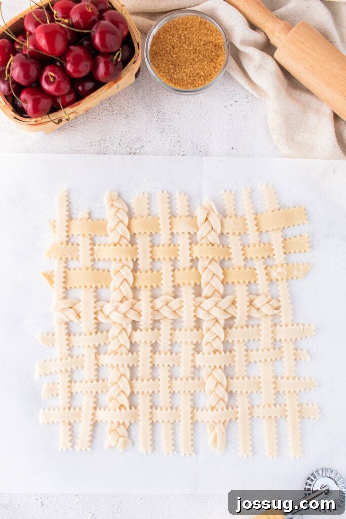 Sweet Cherry Pie Bars 9 Fully assembled unbaked lattice crust laid out on parchment before topping cherry filling