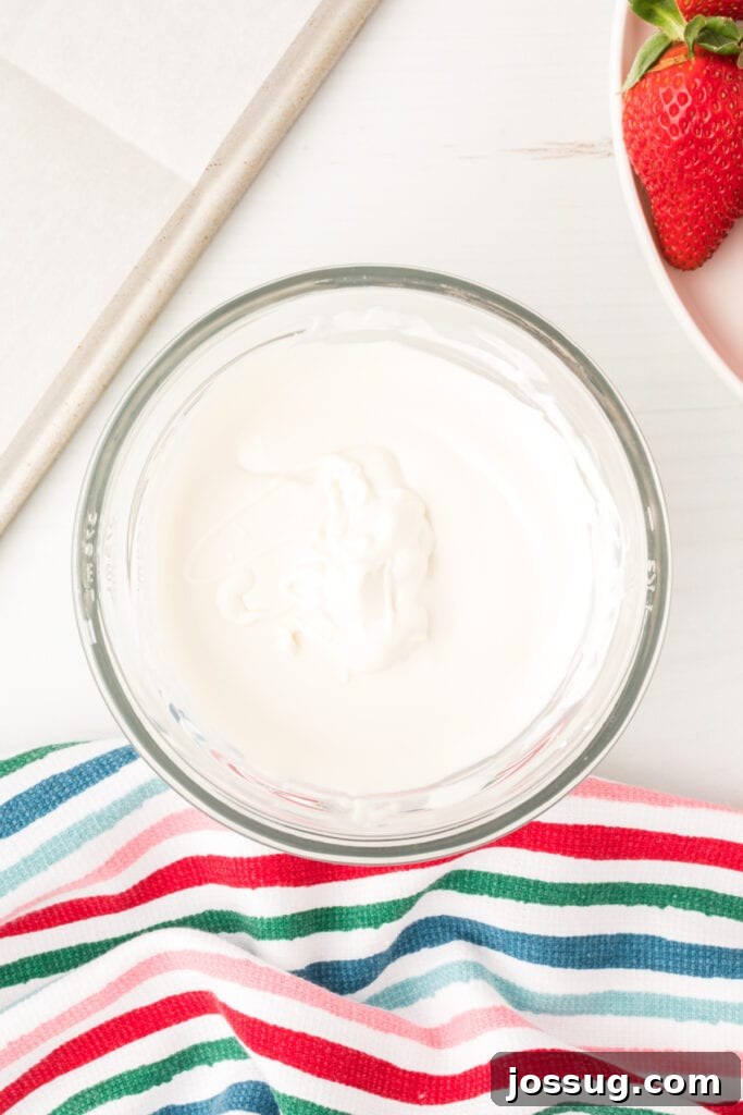 White candy wafers melted in a microwave-safe bowl, ready for dipping.