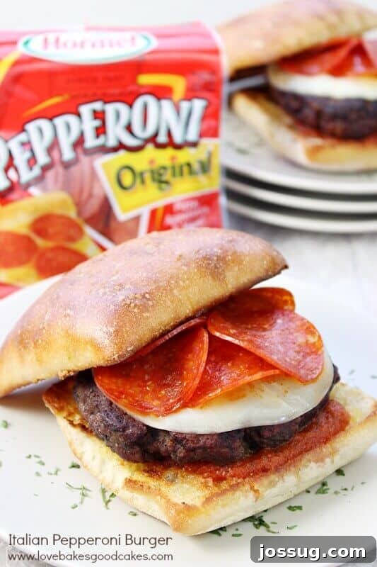 Juicy Italian Pepperoni Burger with melted Provolone and Hormel Pepperoni slices on a perfectly toasted ciabatta bun, served on a rustic plate.