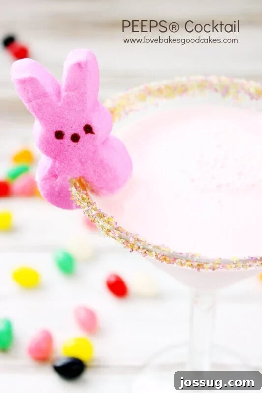 Peeps-Inspired Cocktails 2 A vibrant PEEPS® Cocktail in an elegant glass, featuring a sugared rim and a marshmallow PEEPS® garnish, perfect for Easter celebrations.