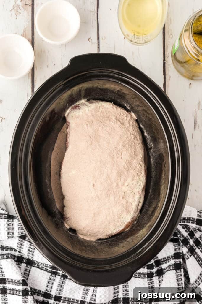 Zesty Slow Cooker Pot Roast 5 Chuck roast in the slow cooker, topped evenly with dry ranch and brown gravy seasoning mixes.