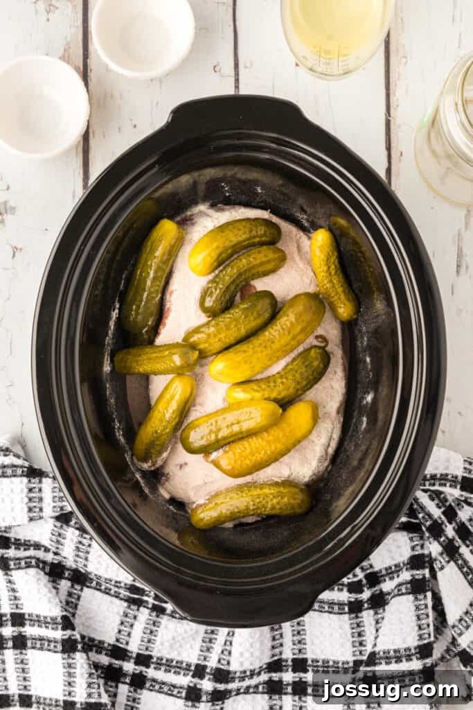 Zesty Slow Cooker Pot Roast 6 Baby dill pickles generously added on top of the seasoned chuck roast in the slow cooker.