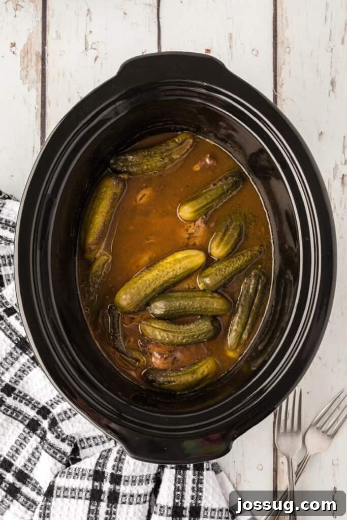 Zesty Slow Cooker Pot Roast 8 Fully cooked, tender dill pickle pot roast submerged in its flavorful juices inside the slow cooker.