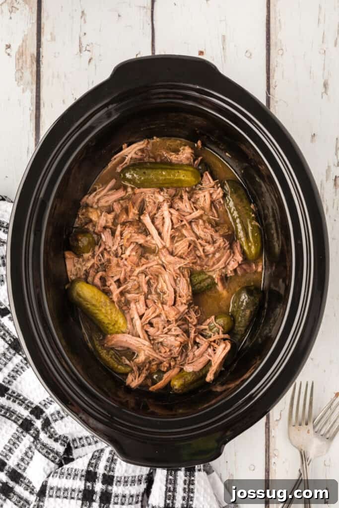 Zesty Slow Cooker Pot Roast 9 Shredded dill pickle pot roast with pickles and ample juices in the slow cooker, perfectly cooked and ready to serve.