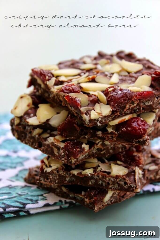 Decadent Dark Cherry Almond Crunch Bars 2 Crispy Dark Chocolate Cherry & Almond Bars stacked on a napkin, showcasing their delicious layers.
