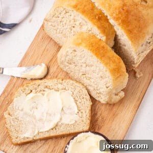 Overhead shot of sliced bread with butter on a board with a butter knife