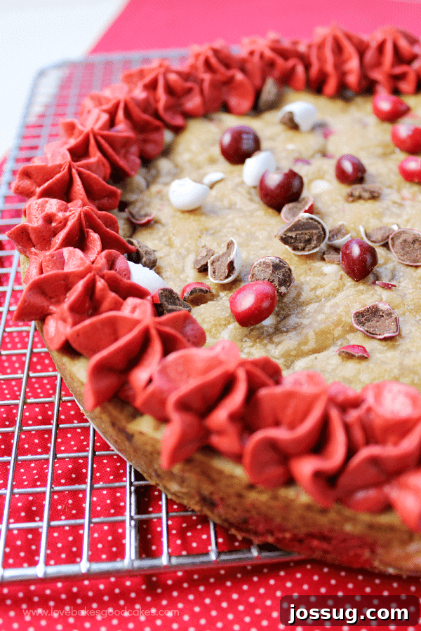 Decadent M&Ms Red Velvet Cookie Cake 2 A delicious slice of M&M's Red Velvet Cookie Cake, showing the vibrant color and festive M&M's.