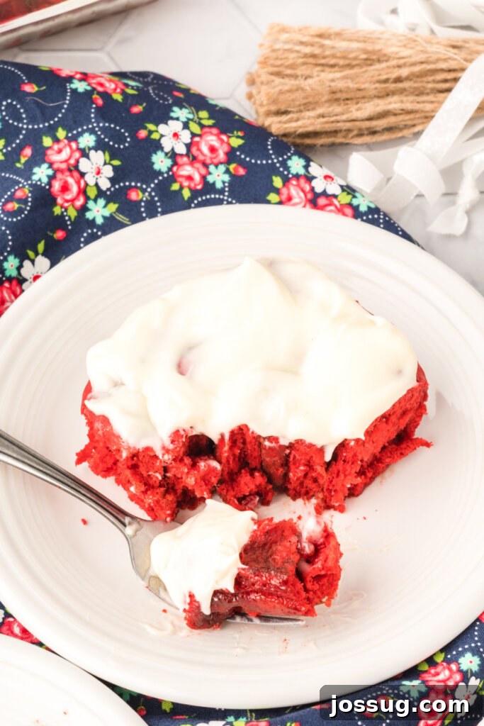 Red velvet cinnamon roll on plate with bite on fork