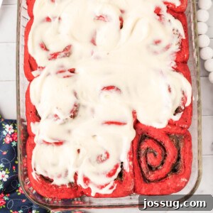 red velvet cinnamon roll swith cream cheese icing in glass pan